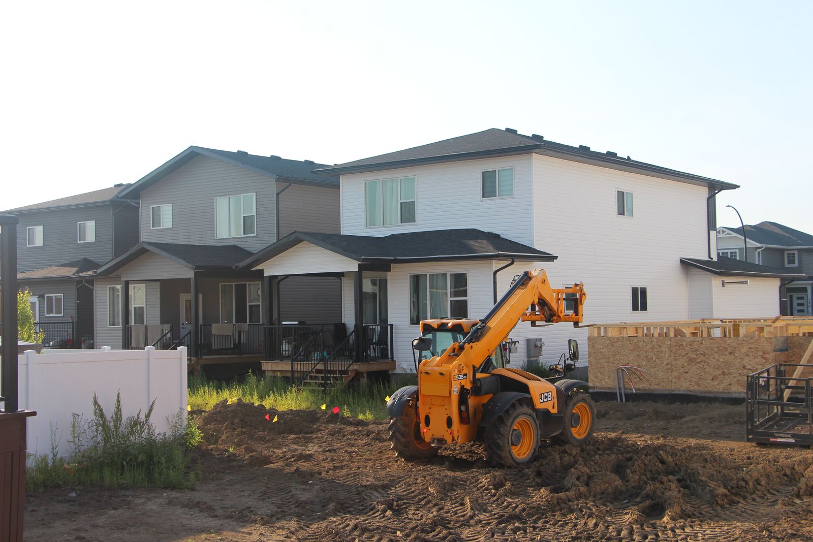 Construction site with loader equipment and framing underway